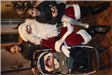 Two Girls and a Baby in a Stroller Beside Santa