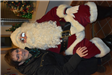 Woman in a Black Coat Takes a Picture with Santa