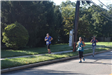 Three Women Running Along the Side of the Road for a 5K