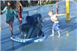Kid Playing Next to a Shark-Themed Fountain