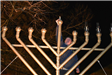 Man Lighting Center Candle of the Menorah