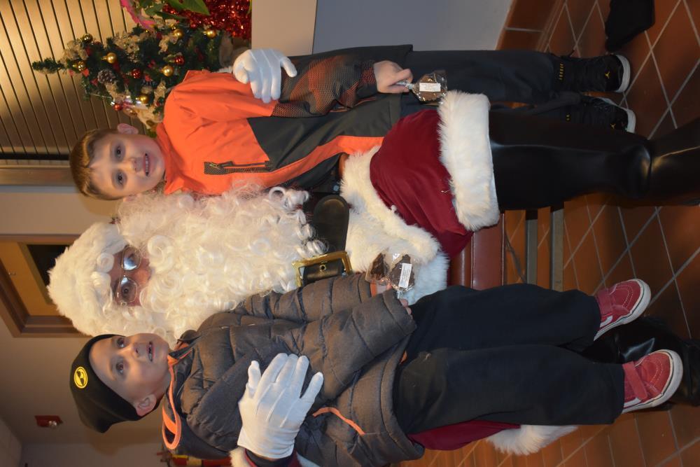 Two Young Boys Take a Picture with Santa