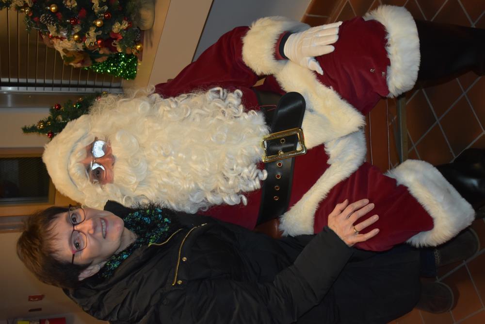 Woman in a Black Coat Takes a Picture with Santa
