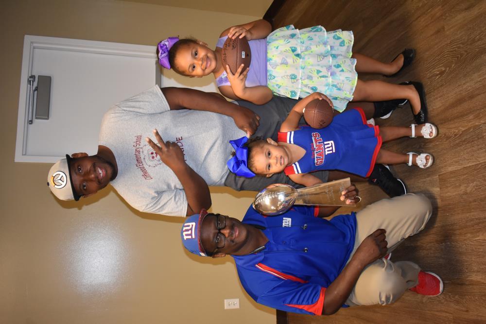 People Take a Picture with a Football Star and His Trophy