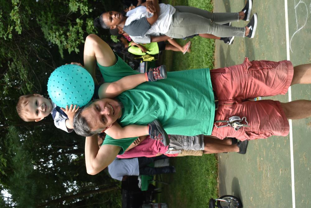 Kid with a Ball on His Dads Shoulders