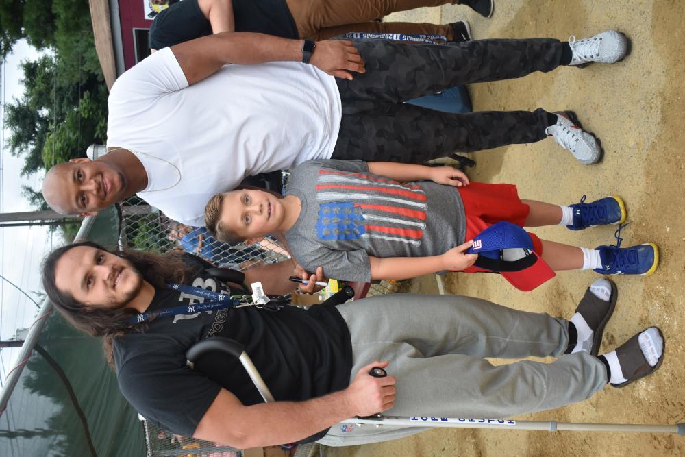 Athletes Take a Photo with a Young Boy