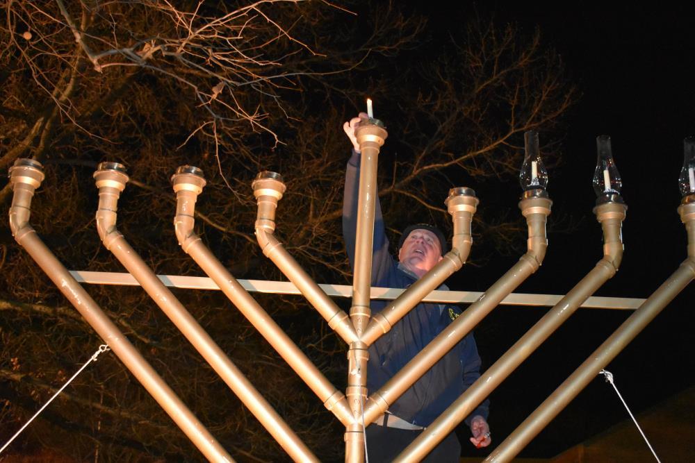 Man Lighting Center Candle of the Menorah