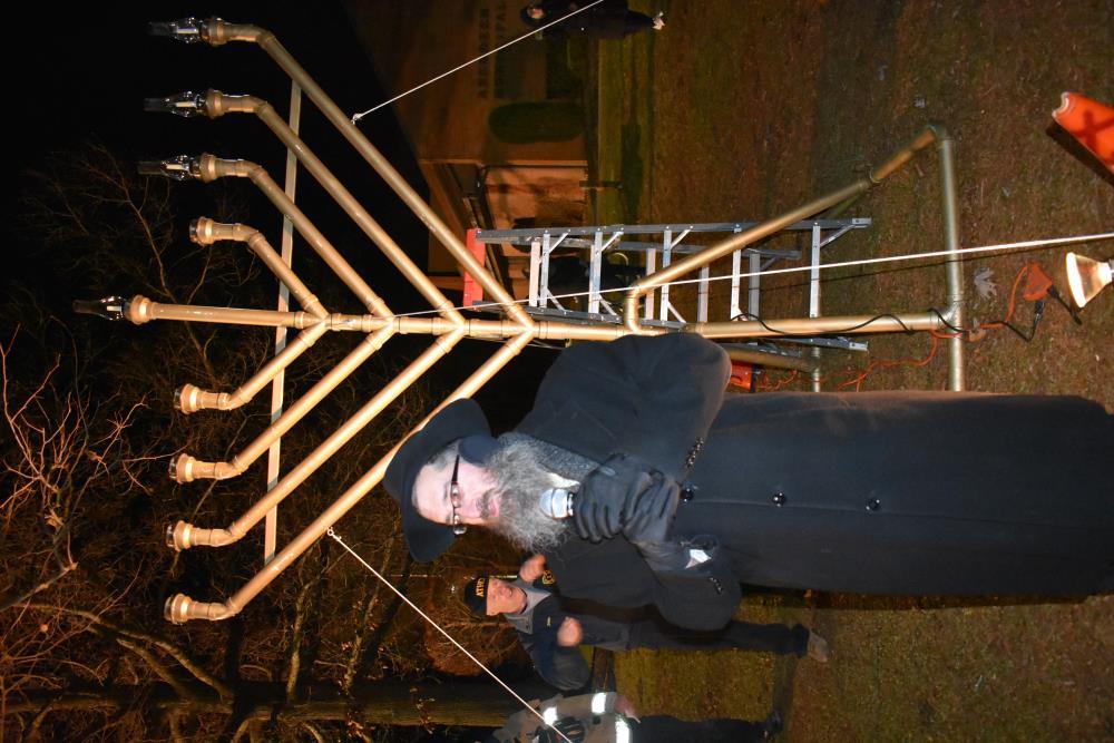 Rabbi Speaking in Front of the Menorah